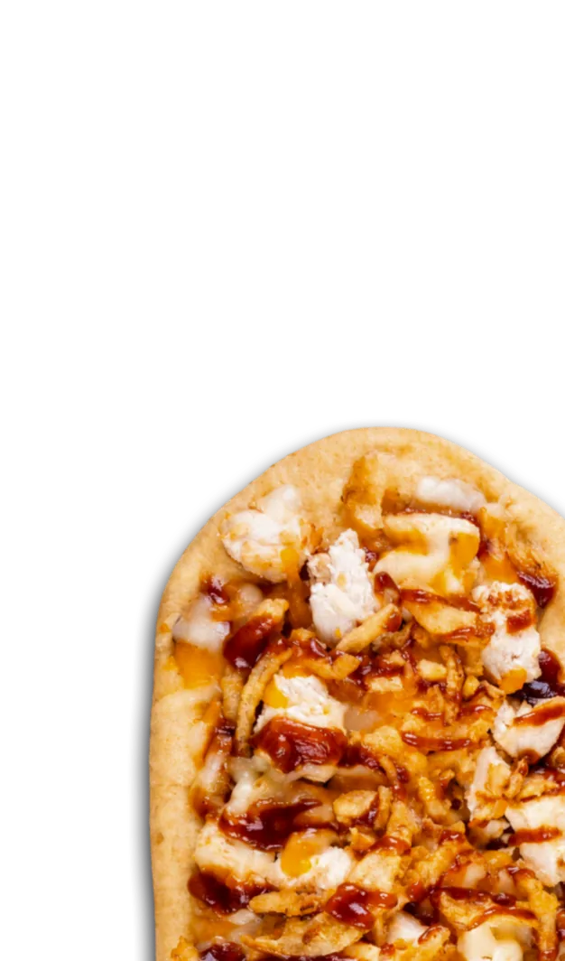 Hand holding a flatbread topped with crispy onions