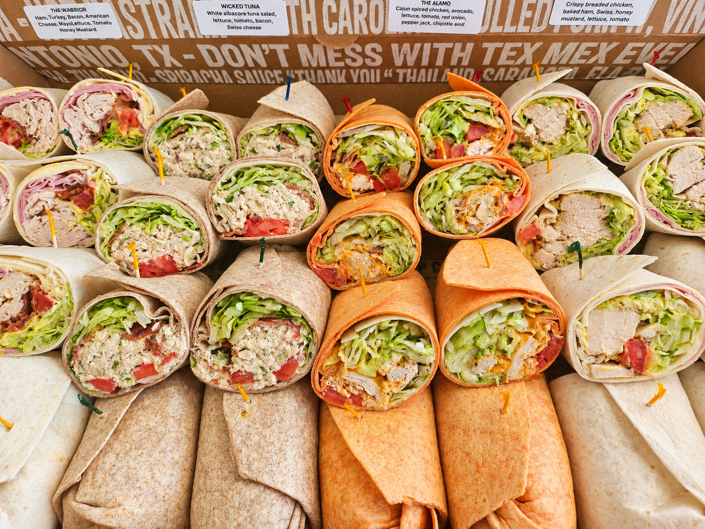 A hand passing a Wrap City takeout bag across the counter